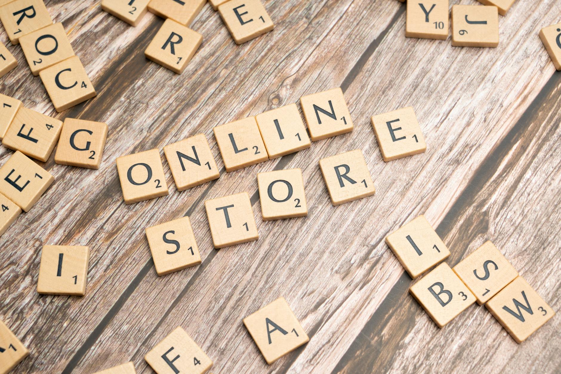 Jak zwiększyć marżę w e-sklepie dzięki inteligentnej polityce rabatowej i upsellingowi Kafelki scrabble układające się w napis online store na drewnianym tle